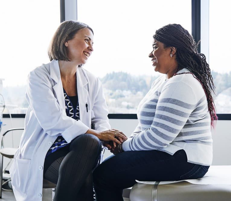 Doctor sitting with an eligible patient in their office and comforting her.